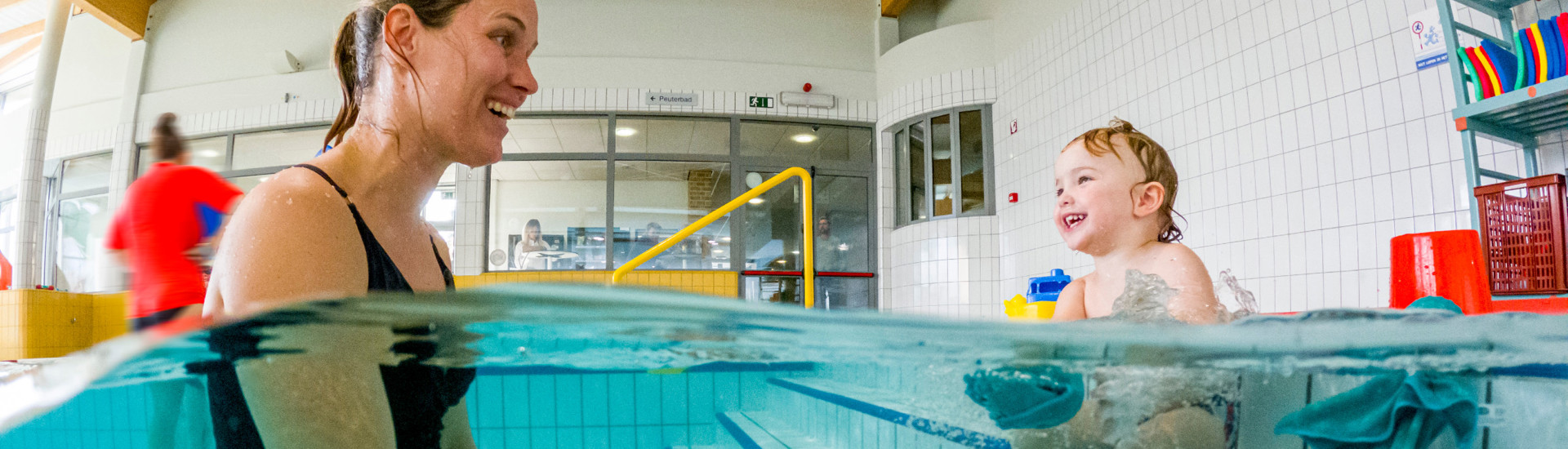 Watergewenning mama en peuter in zwembad