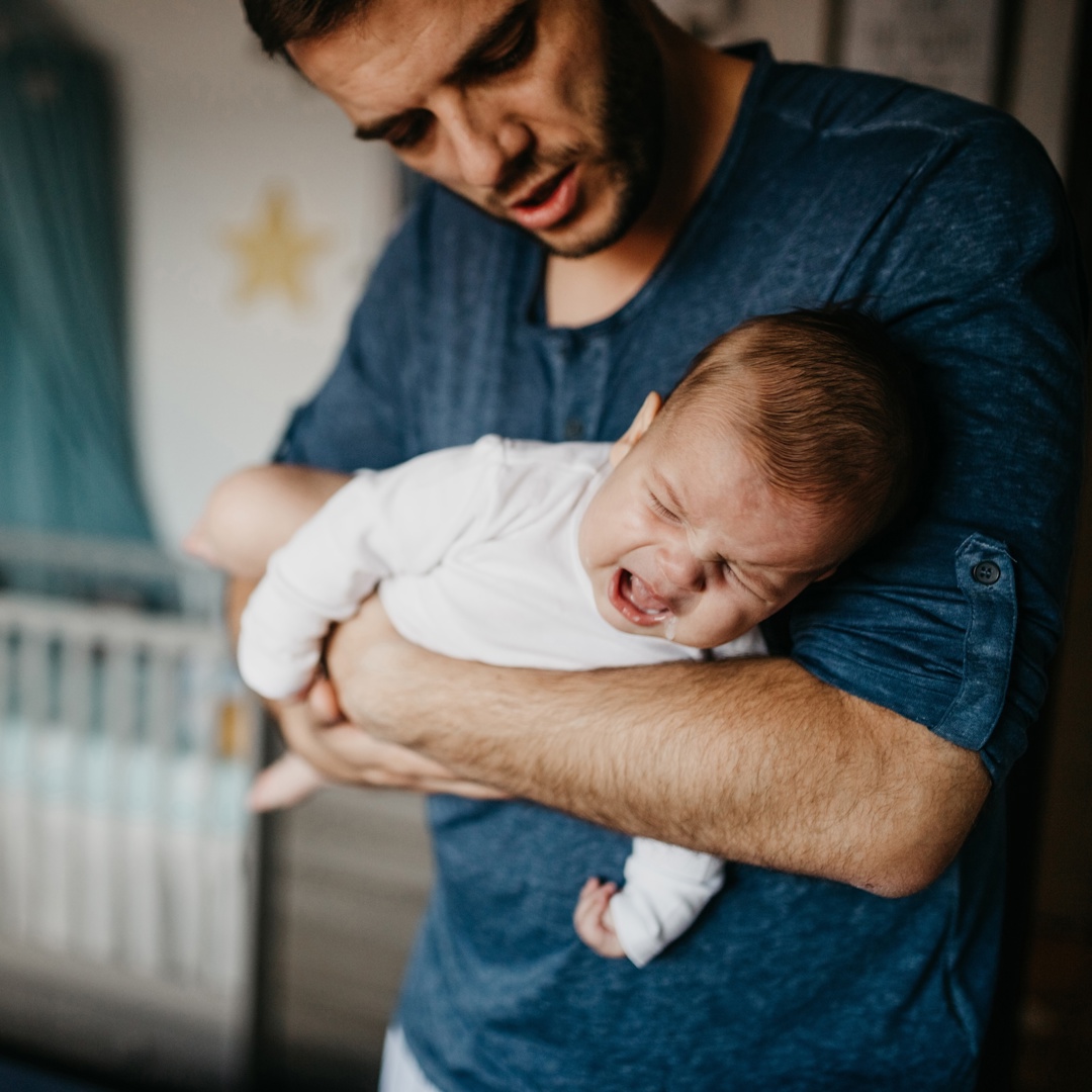 Vader met huilbaby in armen