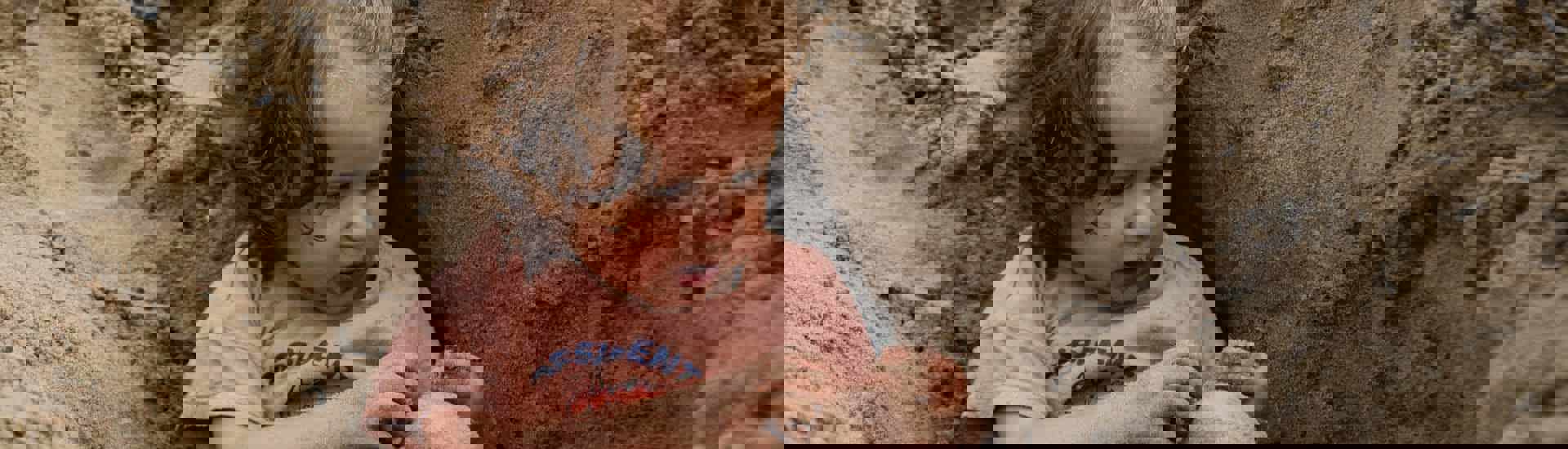 Baby Jutta speelt in het zand: al 16 maanden