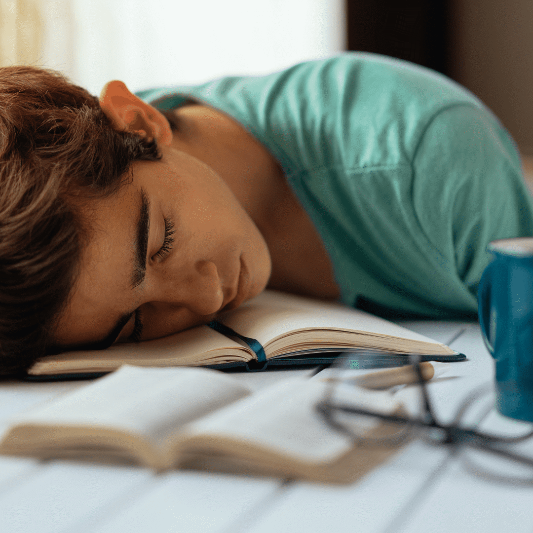 Kind slaapt op boek: Slaaptekort bij tieners