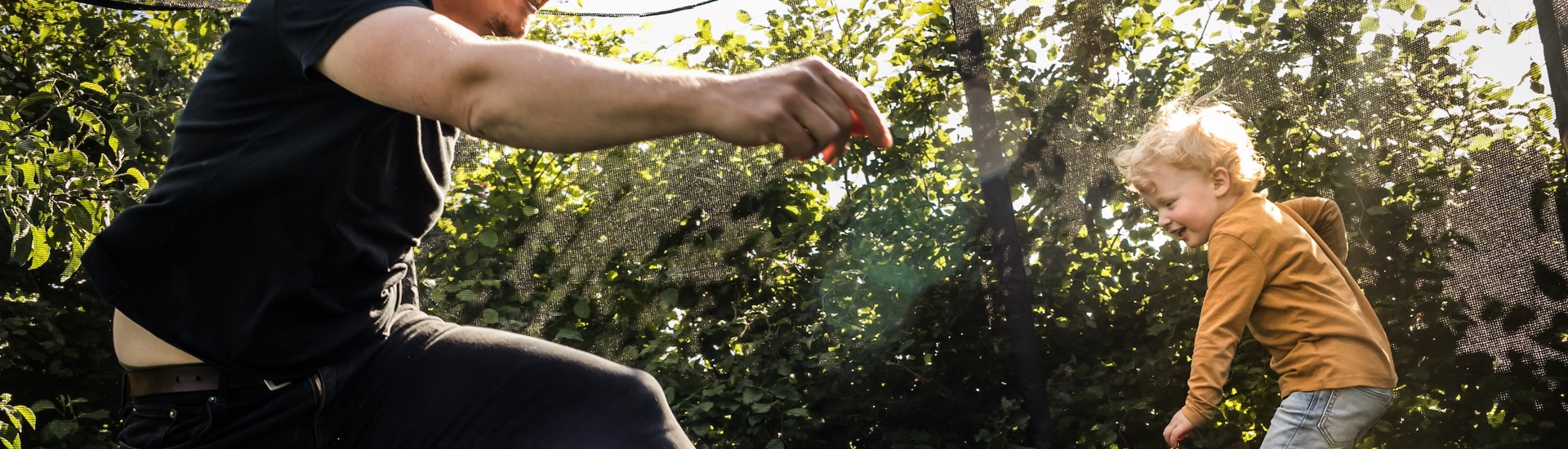 Vader en zoon op trampoline hebben jongens andere opvoeding nodig dan meisjes