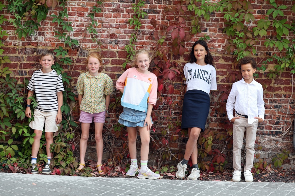 5 kleine kinderen buiten tegen muur praten eerlijk over praten met je kinderen