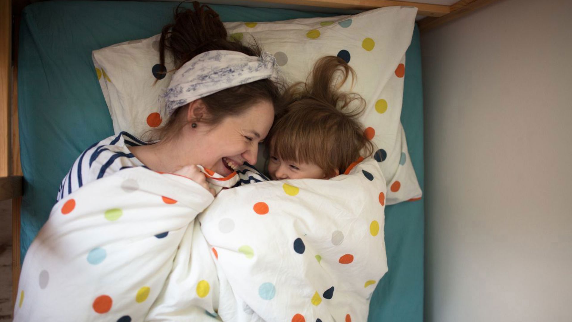 Gezinsbond mama en zoontje knuffelen in bed