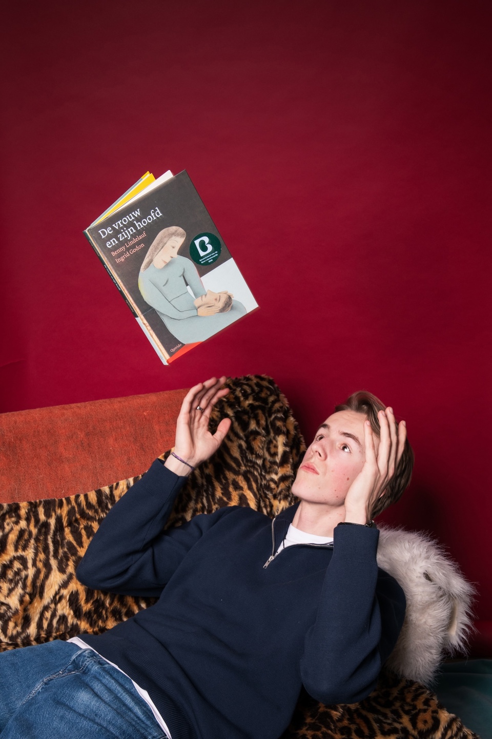 Ruben ligt op sofa en leest boek De vrouw en zijn hoofd voor de leesclub