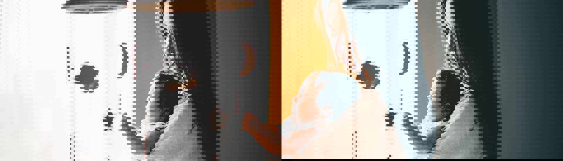 Mama geeft baby bij babybedje: een slaapritueel geven