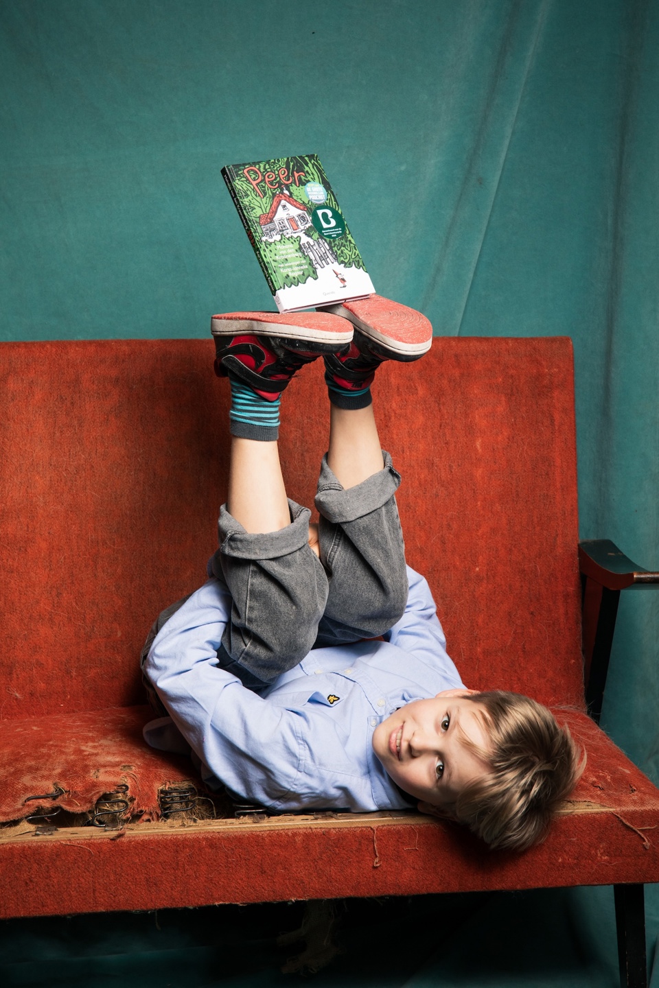 Stan op sofa leest boek Peer voor de leesclub