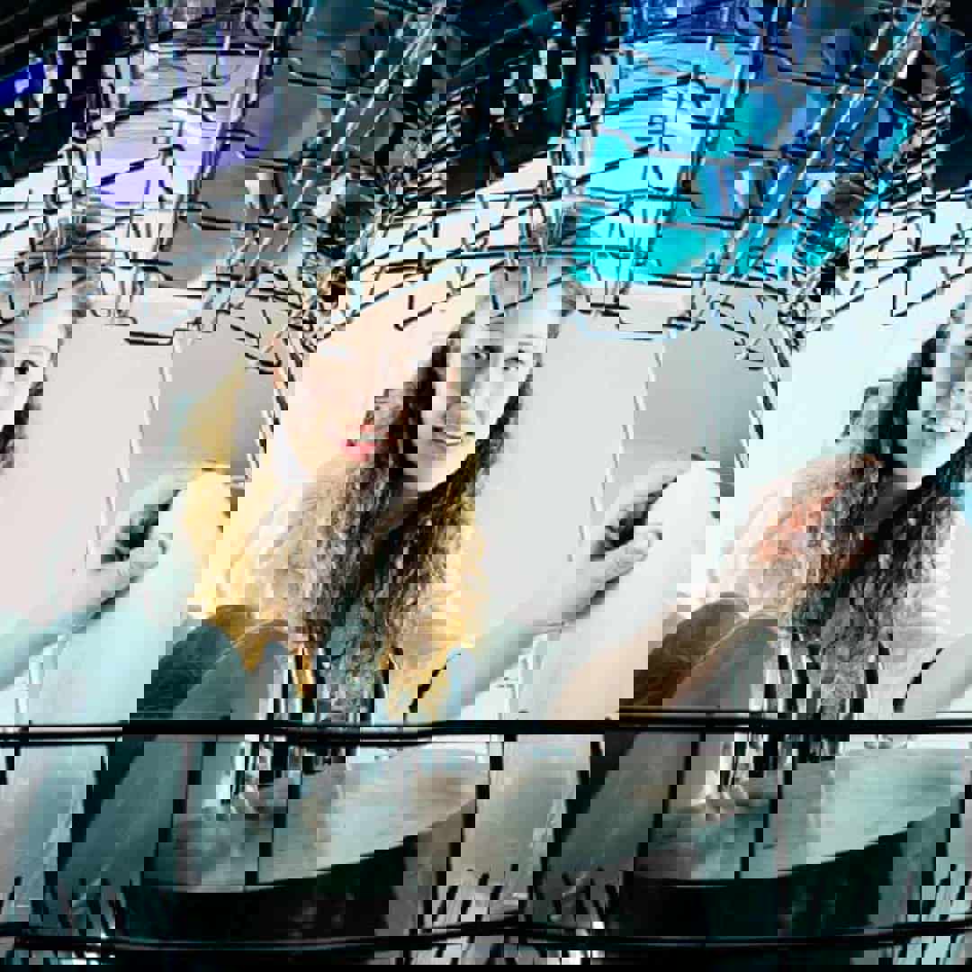 Tiener helpt in het huishouden en laadt de afwasmachine in