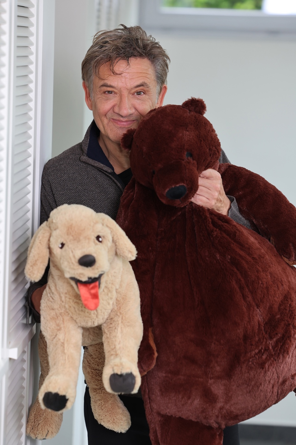 Grootvader Bart Peeters heeft twee knuffels vast