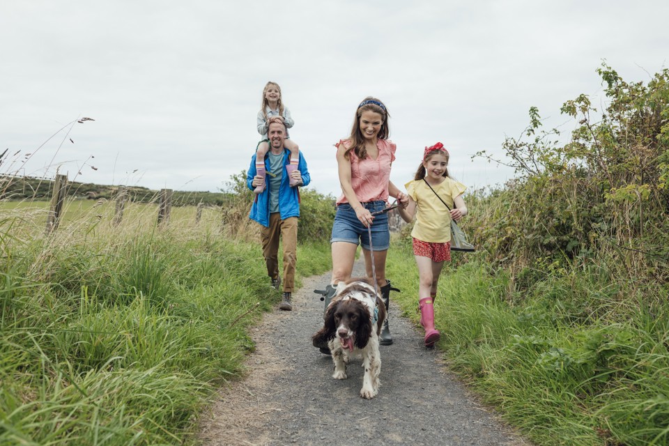 Gezin wandelt met hond in natuur - Rituelen tijdens schooljaar zorgen voor meer verbinding