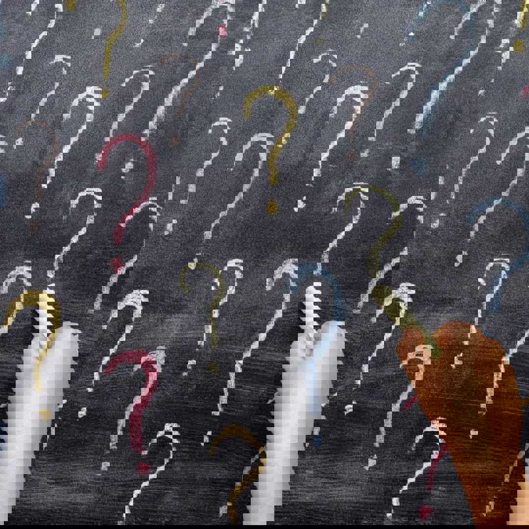 Kinderhand tekent vraagteken op bord: waarom vragen kleuter