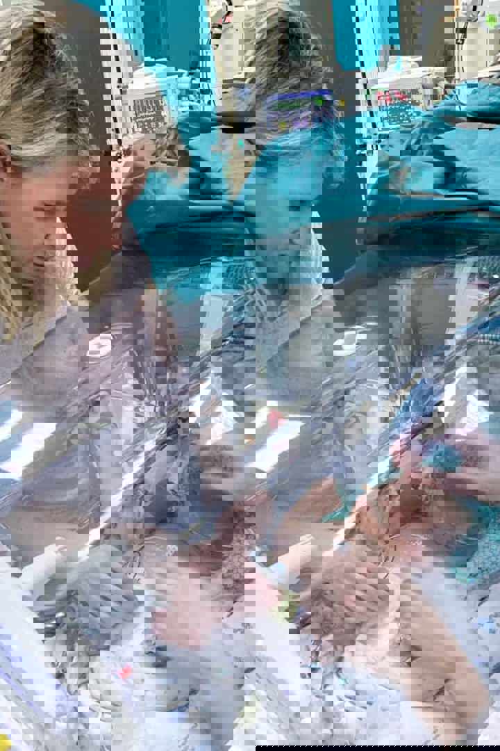 Mama Ruth kijkt naar premature baby Liz in couveuse