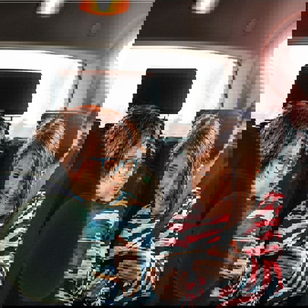 Kinderen zitten met smartphones in de auto