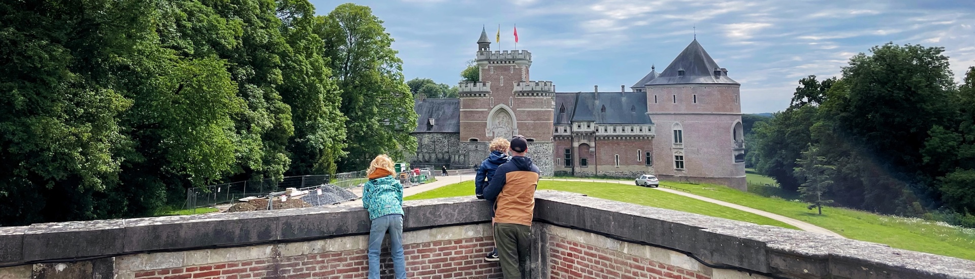 Twee kinderen samen met papa met Kasteel Van Gaasbeek op achtergrond