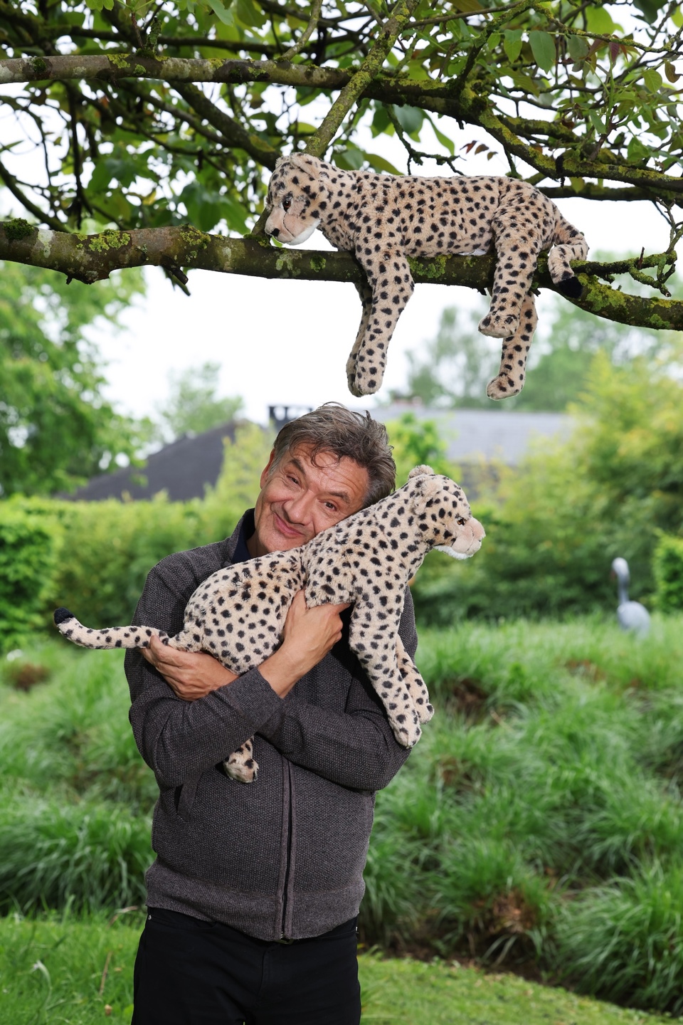 Bekende Grootvader Paps Bart Peeters staat in tuin met twee knuffels